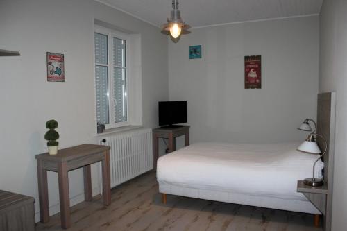 a white bedroom with a bed and a television at AUBERGE DU CANAL in Houdelaincourt