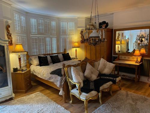 a bedroom with a bed and a chair and a mirror at Olivia House in Porthcawl