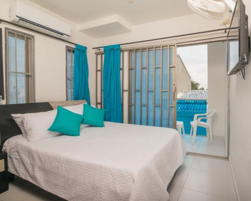 - une chambre avec un grand lit et des rideaux bleus dans l'établissement Cabana Costa Azul, à Coveñas