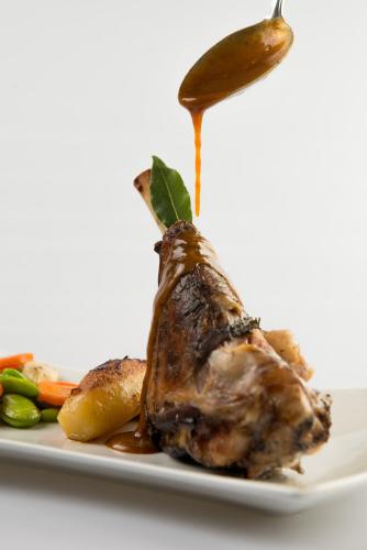 a piece of meat with sauce on a plate with vegetables at Logis Hotel Restaurant A L'Etoile in Mittelhausen