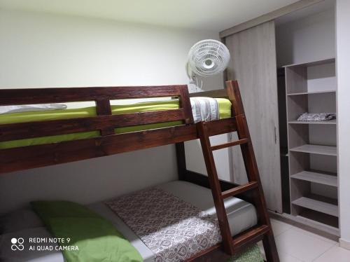 a bunk bed with a ladder in a room at Casa de verano in San Jerónimo