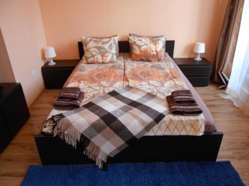 a bed with a blanket and pillows on it at Studio D-55 in Borovets Gardens hotel in Borovets