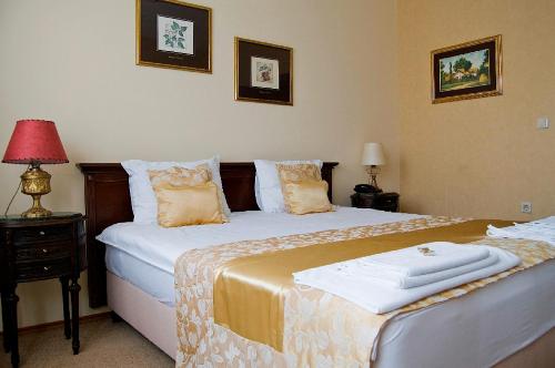 a bedroom with two beds and a table with a lamp at Garni Hotel Andric in Sombor
