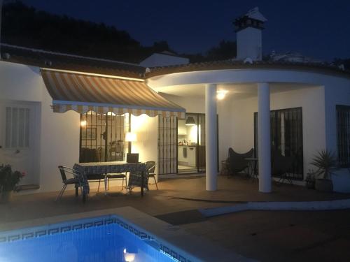 a patio with a table and a pool at night at Belvilla by OYO Villa in Arenas with Private Pool in Arenas