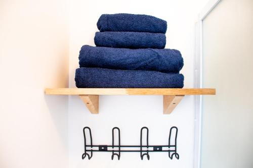 une pile de serviettes bleues sur une étagère en bois dans l'établissement Studio Cosy sur île de Nantes - Proche Tram 2 et 3, à Nantes