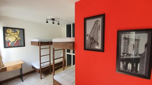 ein Zimmer mit einer roten Wand und einem Etagenbett in der Unterkunft Hostal Base Camp México in Orizaba
