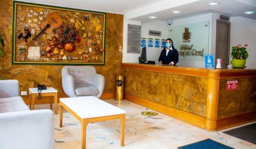 a woman is standing behind a counter in a waiting room at Hotel Sogamoso Real in Sogamoso