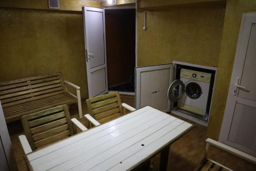 ECOPANA في Türkistan: غرفة مع طاولة وكراسي وغسالة ملابس