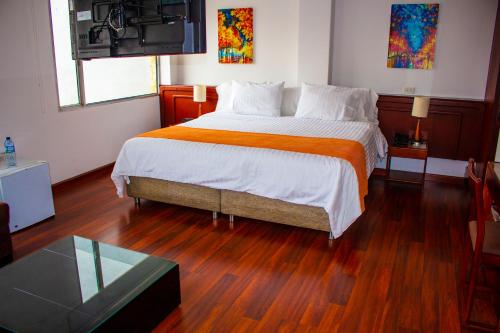 a bedroom with a large bed and a glass table at Hotel Sogamoso Real in Sogamoso
