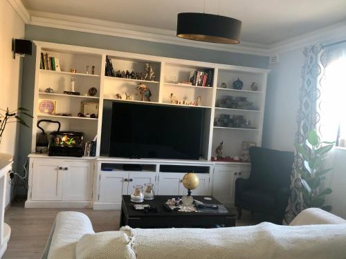 a living room with a large entertainment center with a flat screen tv at Spacious Private Room 5 Minutes from Malta Airport Private Bathroom Kitchen Access Quiet Area Friendly Labrador Candy in Safi
