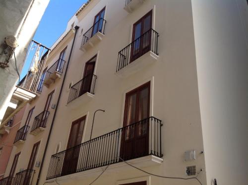 un edificio bianco con balconi sul lato di Le Luci al Porto a Trapani
