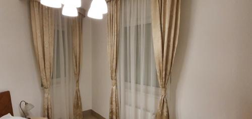 a bedroom with a curtain and a chandelier at Glambeauty1 in Jagodina