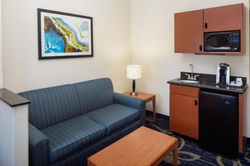 a living room with a couch in a hotel room at Holiday Inn Express & Suites Midland Loop 250 by IHG in Midland