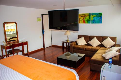 a living room with a couch and a flat screen tv at Hotel Sogamoso Real in Sogamoso