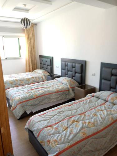 sypialnia z 3 łóżkami w pokoju w obiekcie residence akram m'diq w mieście Mʼdik