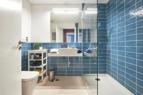 baño con paredes de azulejos azules y lavabo en Solar do Monte, en Estoril