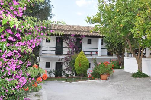 a white house with flowers in front of it at Kahlua in Liapades