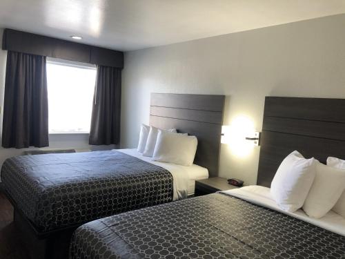 En eller flere senge i et værelse på Americas Best Value Inn & Suites Near Frost Bank Center