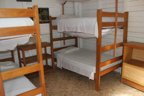 a room with three bunk beds and a desk at Tambopata Hostel in Puerto Maldonado