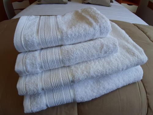 uma pilha de toalhas sentadas em cima de uma cama em Departamento en Barrio Centrico Bariloche (PE) em San Carlos de Bariloche