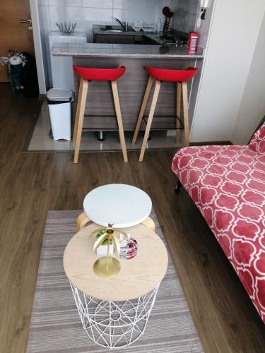 a living room with a table and two stools at 2 Torres Calama in Calama