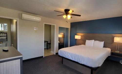 a bedroom with a bed and a ceiling fan at Beachwalker Inn & Suites in Pismo Beach