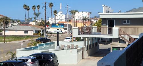a parking lot with cars parked in front of a building at Beachwalker Inn & Suites in Pismo Beach