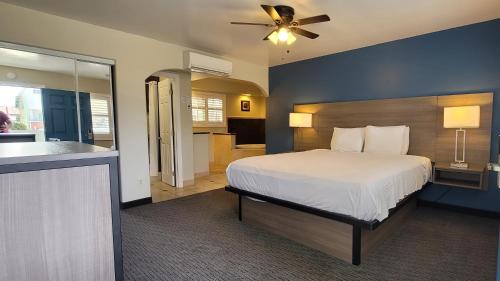 a bedroom with a king sized bed and a kitchen at Beachwalker Inn & Suites in Pismo Beach