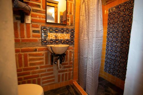 baño con aseo y pared de ladrillo en Majikal B&B - Barro Negro, en Cholula