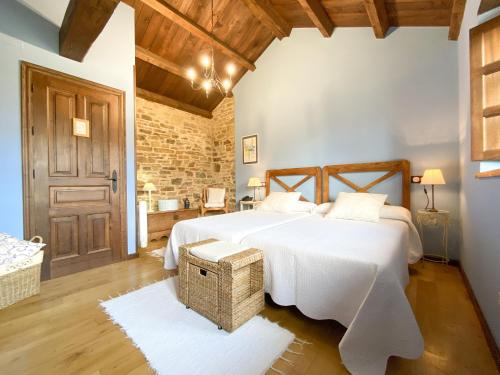 Un dormitorio con una gran cama blanca y una pared de ladrillo en Hotel Casa Cachón, en Tol