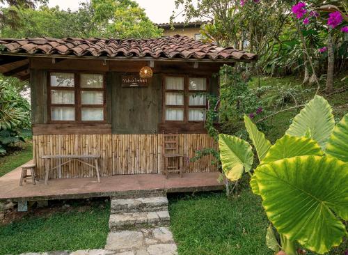 una pequeña casa de madera con mesa y banco en Cabañas Los Achicuales en Cuetzalán del Progreso