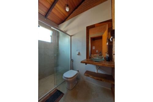 a bathroom with a shower and a toilet and a sink at Villa da Serra Ibitipoca chalé família in Conceição da Ibitipoca