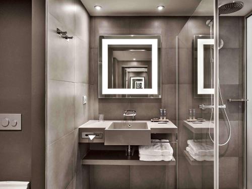 a bathroom with two sinks and a shower at Novotel Moscow Kievskaya in Moscow