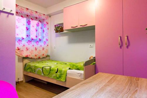a small bedroom with a bed and a pink cabinet at Apartment Stinjan, Istria 2 in Štinjan