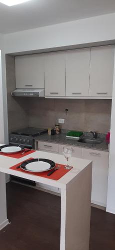 a kitchen with white cabinets and a red counter top at Departamento en Barrio Centrico Bariloche (PE) in San Carlos de Bariloche
