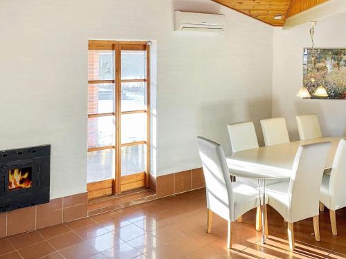 uma sala de jantar com uma mesa e cadeiras e uma lareira em 8 person holiday home in R dby em Kramnitse