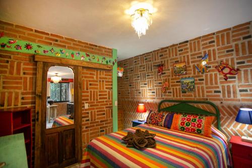 - une chambre avec un lit et un mur en briques dans l'établissement Majikal B&B - Alebrijes, à Cholula