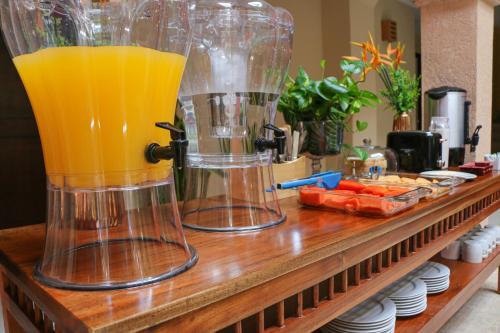two glass blenders sitting on a counter with orange juice at Hotel Gayser in Valladolid
