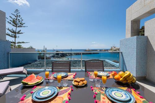 a table with food and drinks on top of a balcony at BeachFront in Puerto Mogán in Puerto de Mogán