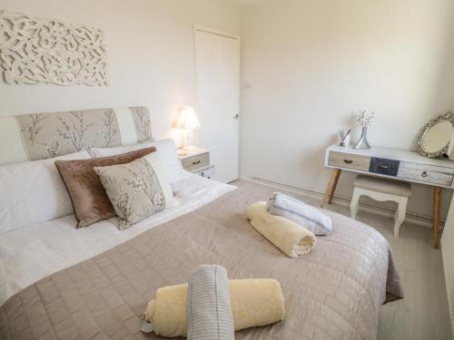 een slaapkamer met een groot bed en een bureau bij Sunset Sands in Conwy