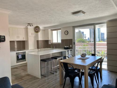 cocina y comedor con mesa y sillas en Wharf Boutique Apartments, en Gold Coast