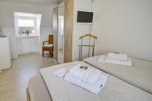 ein Hotelzimmer mit 2 Betten und Handtüchern darauf in der Unterkunft fewo1846 - OstseeFlair komfortables Reihenhaus mit zwei Schlafzimmern, Garten und Terrasse in Flensburg