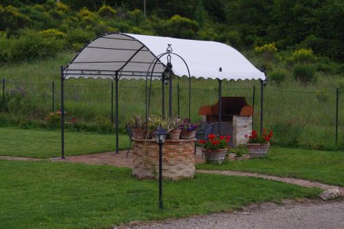 a gazebo with potted plants in a yard at La Fornace di San Galgano in Chiusdino