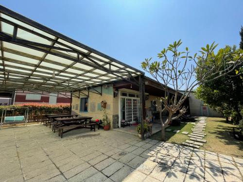 a patio with picnic tables and a building at 花宿 民宿 in Xiaoliuqiu