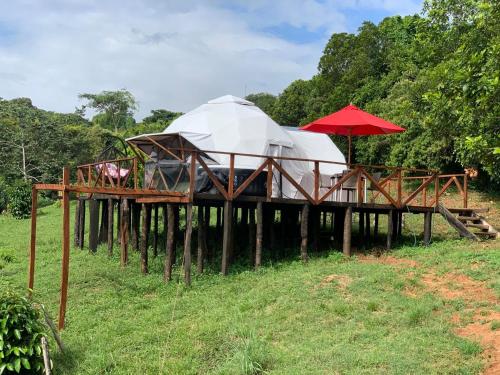 a building with two domes and a red umbrella at Eco-Glamping Shalom in Mariquita