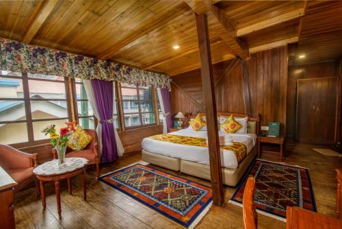 a bedroom with a bed and a couch and a table at Muscatel Himalayan Resort - 400 Mts from Mall Road in Darjeeling