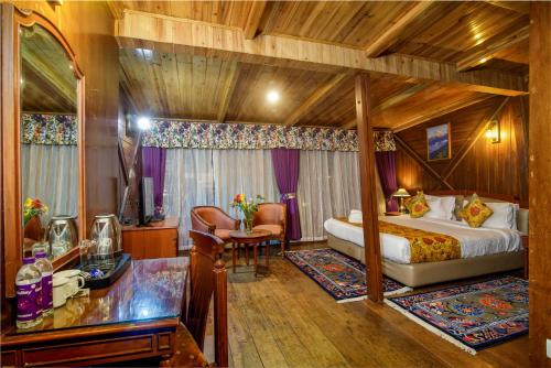 ein Schlafzimmer mit einem Bett und einem Schreibtisch in einem Zimmer in der Unterkunft Muscatel Himalayan Resort - 400 Mts from Mall Road in Darjeeling