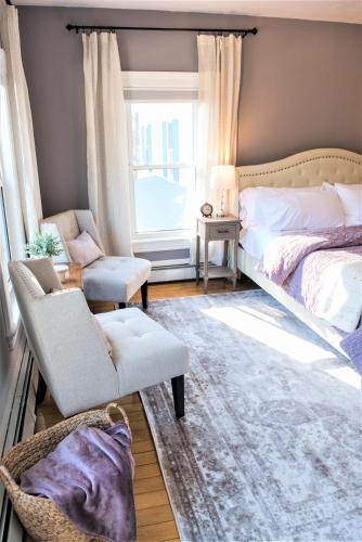 a bedroom with a bed and a chair and a window at Inn on Golden Pond in Holderness
