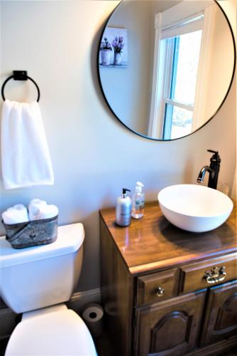 a bathroom with a white toilet and a mirror at Inn on Golden Pond in Holderness