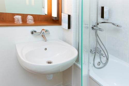 a bathroom with a sink and a shower at Campanile Paris Est Bobigny in Bobigny